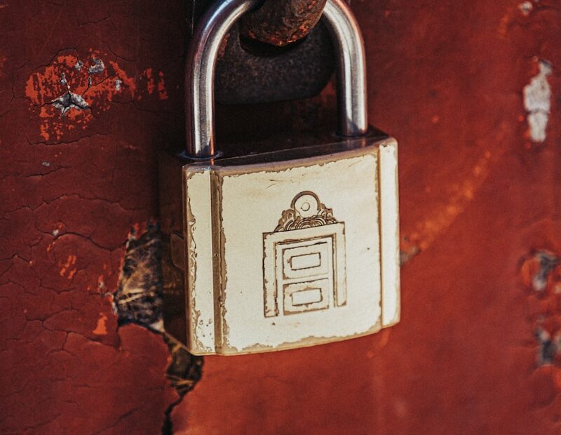 a padlock attached to a rusted red wall